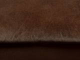 a brown leather couch with a brown pillow on it