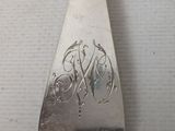 a silver spoon with a monogram on it sitting on a table