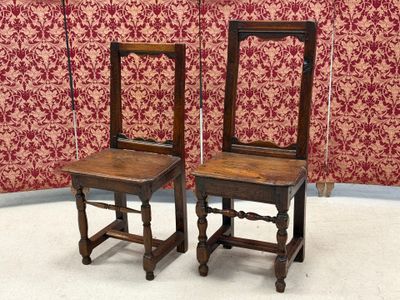 two wooden chairs sitting next to each other on the floor