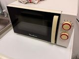 a microwave on top of a washing machine in a kitchen