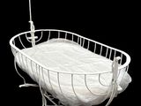a white baby crib with a white blanket on it