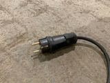 a black cord on the ground next to a black plug
