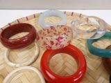 many different colored bracelets sitting on a bamboo tray