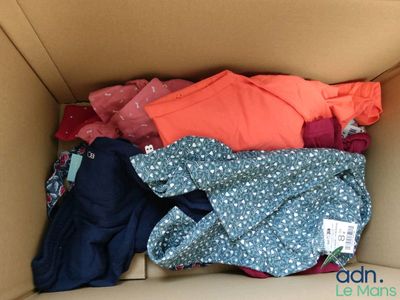 a cardboard box filled with clothes and clothing items