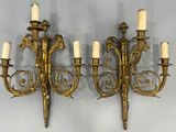 pair of antique brass wall sconces with white candles