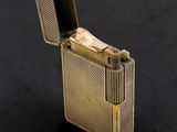 briquet doré posé sur une surface noire, avec un briquet au centre
