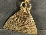 a gold plated pendant with an image of a woman in a dress