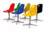 quatre chaises de couleurs différentes alignées sur une surface blanche