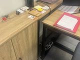 a desk with a computer and a chair in the corner