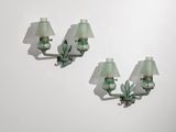 une paire d'appliques murales en verre vert fixées à un mur blanc