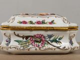 a white and gold box with flowers and birds on it