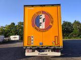 a truck that is parked in a lot with trees in the background