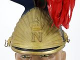 a gold helmet with a red feather on top of it
