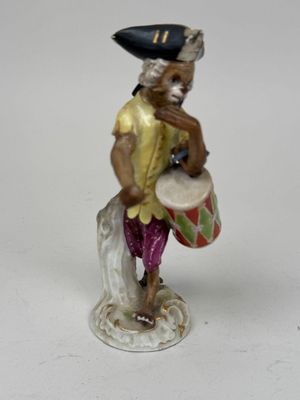 a figurine of a man with a drum and a hat