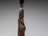 a bronze statue of a woman holding a bird on her head