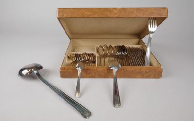 des couverts dans un coffret en bois, avec des cuillères et un repose-cuillère posés sur une table