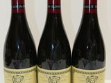 trois bouteilles de vin posées sur une table l'une à côté de l'autre
