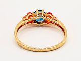 a close up of a gold ring with a blue topaz and orange topaz