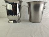 pair of silverplated ice buckets on a white tablecloth
