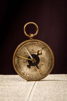 a gold compass sitting on top of a table