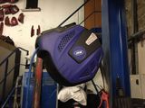 a blue suitcase sitting on top of a blue cart in a garage