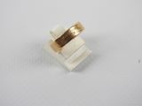 a close up of a gold ring on a white surface