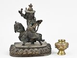 a statue of a man riding a horse next to a vase