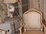 a room with a lot of chairs and a table with a lamp on it