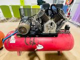 a red air compressor sitting on top of a red tank
