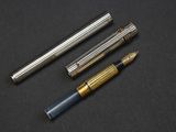 three different types of fountain pens on a black surface