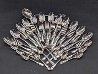 une image représentant un tas de cuillères en argent posées sur une surface noire