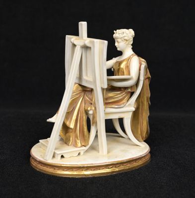 an image of a figurine of a woman sitting at a easel