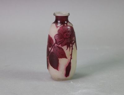 un vase rouge et blanc posé sur une surface blanche