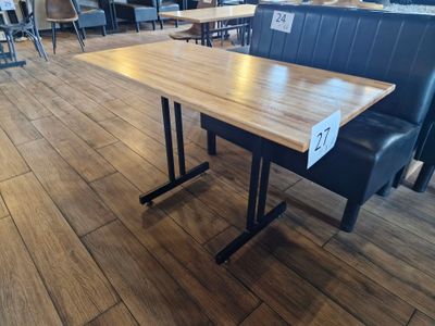 une table en bois et des chaises noires dans un restaurant