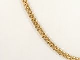 a close up of a gold chain on a white surface