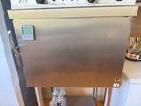a stainless steel oven sitting on a cart in the kitchen