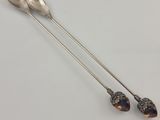 two spoons and a spoon rest on a white surface