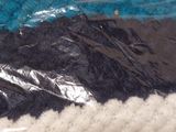 a blue and black knitted hat on a white table