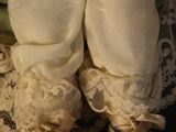 a close up of a baby doll on a lace table cloth