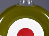a glass bottle with a red circle on it next to a clock