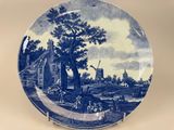 a blue and white plate with a picture of a farm scene on it