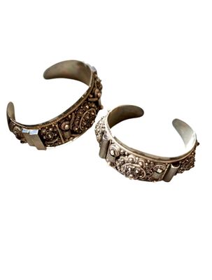 une paire de bracelets manchette en argent sur fond blanc