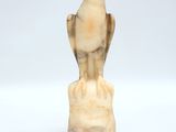 carved ivory figurine of a bird on a rock