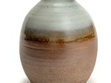 a brown and white vase sitting on a white surface