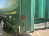 a green truck that is parked on the side of the road
