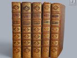 trois vieux livres sont empilés sur une table