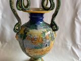 un vase bleu et vert muni de deux anses, sur fond blanc