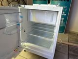 a white refrigerator with its door open on the floor