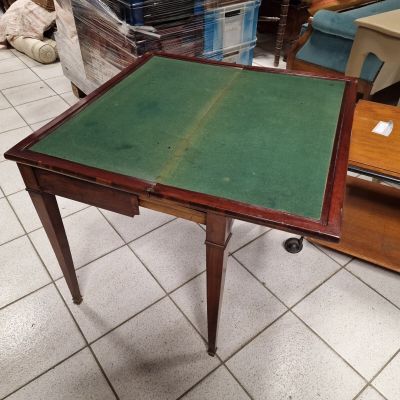 a small table with a green top on a tile floor