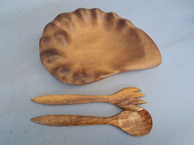 deux cuillères en bois et une assiette en bois posées sur une table